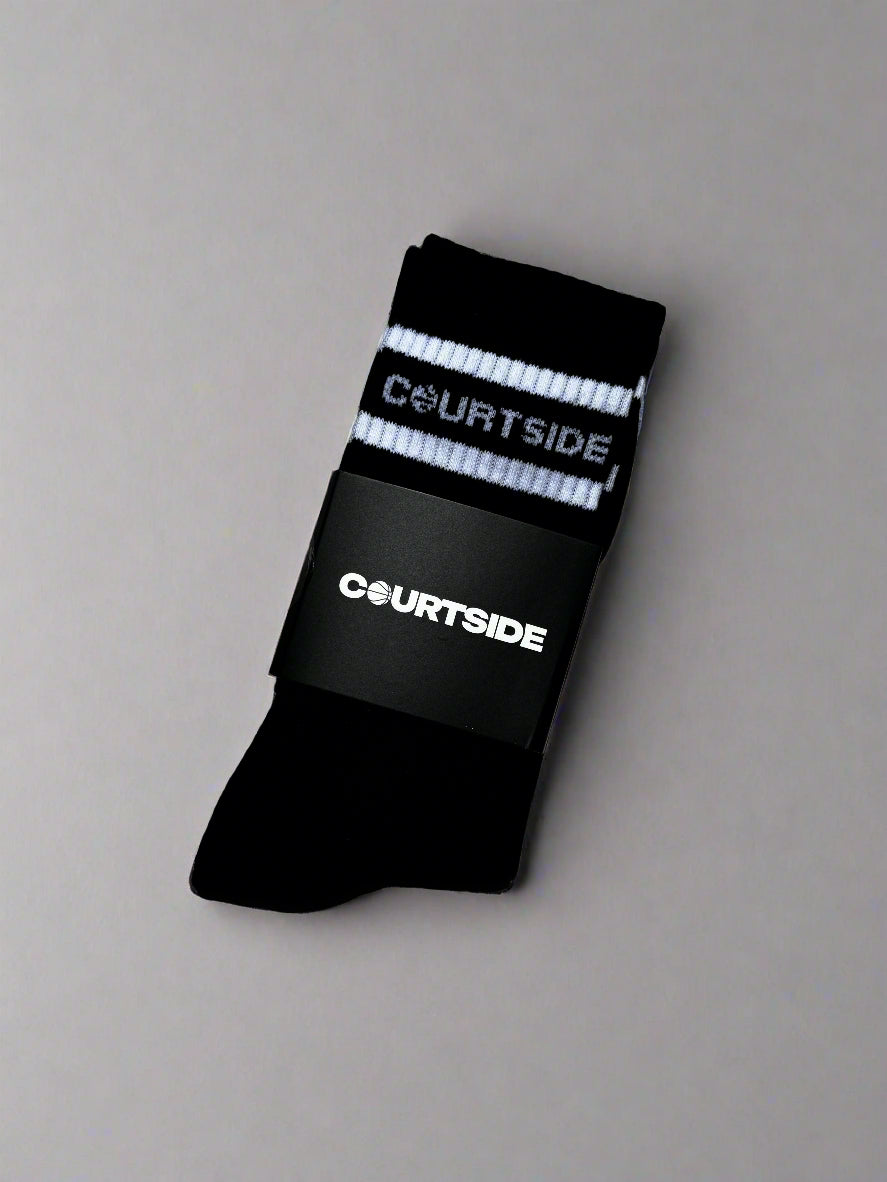 Black socks with white stripe and courtside signature logo shown in packaging