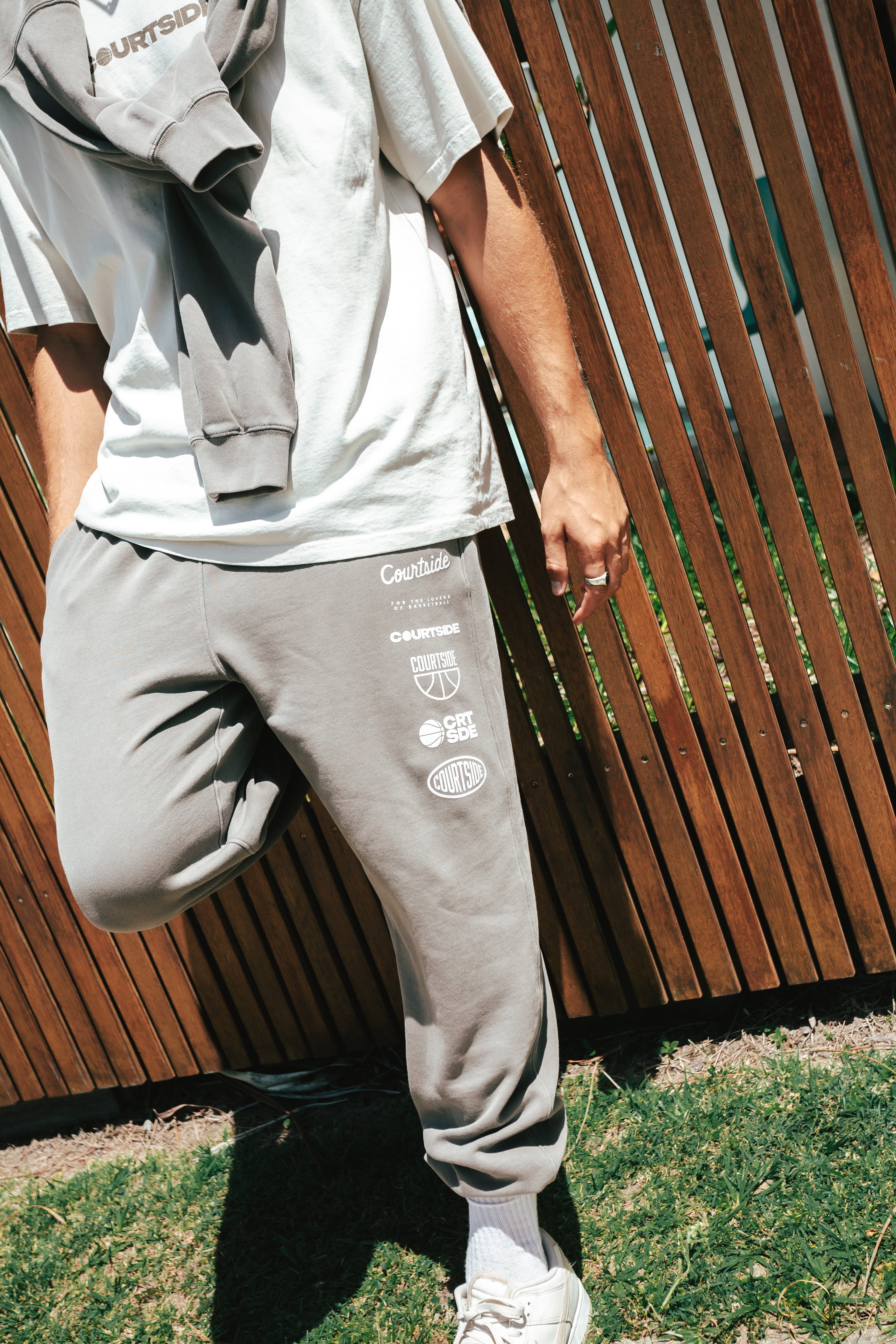 NBL Player Nelson Kahler wearing the Courtside Bench Track Pants in Faded Grey colour.