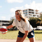 Female basketball player wearing the Courtside Black & Royal Blue DPOYW basketball short in women's cut showing details