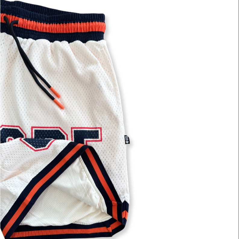 Courtside DPOY basketball shorts in cream with orange & black highlights, shown as a close up