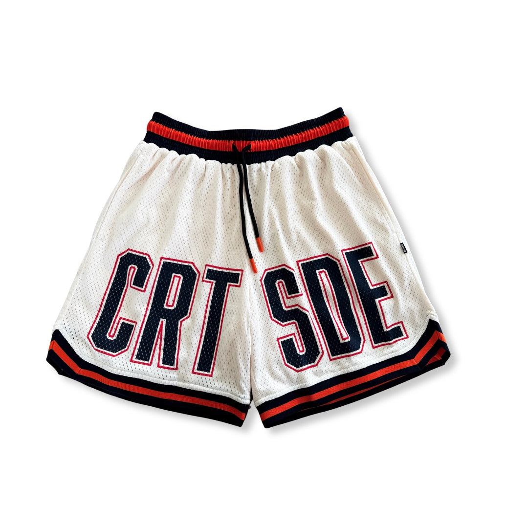 Courtside DPOY basketball shorts in cream with orange & black highlights shown as a flatlay