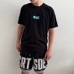 Black basketball shorts on tall male with white large letters across front CRT SDE short for Courtside with Teal detailing.