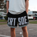 Courtside Black basketball shorts on Louis Lauret elite junior basketball player with white large letters across front CRT SDE short for Courtside with Teal detailing.