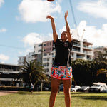 NBL1 player Ash Frampton shooting hoops wearing MVPW orange and colourful basketball shorts and black champs tee at Cotton Tree outdoor court in Sunshine Coast