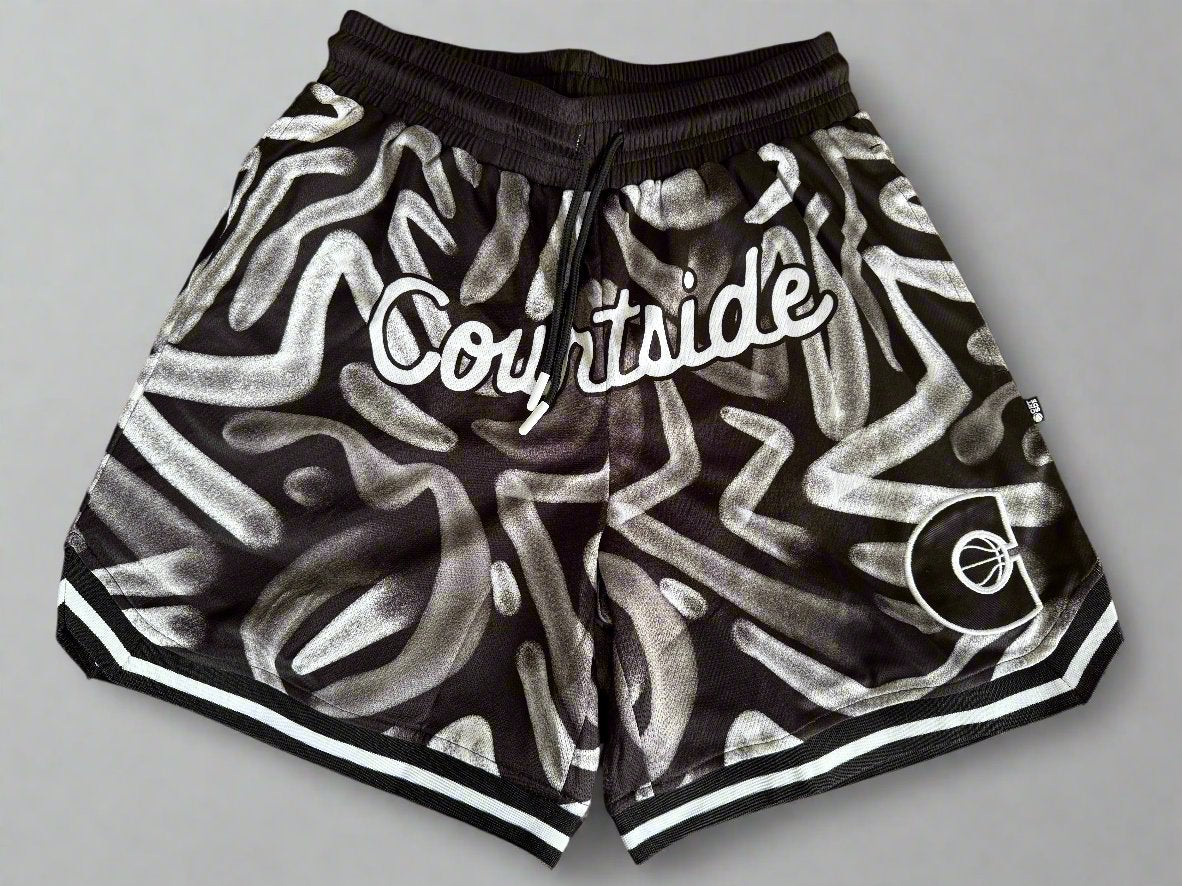 Courtside ROTY basketball shorts in white and black pattern laid flat on table with grey background