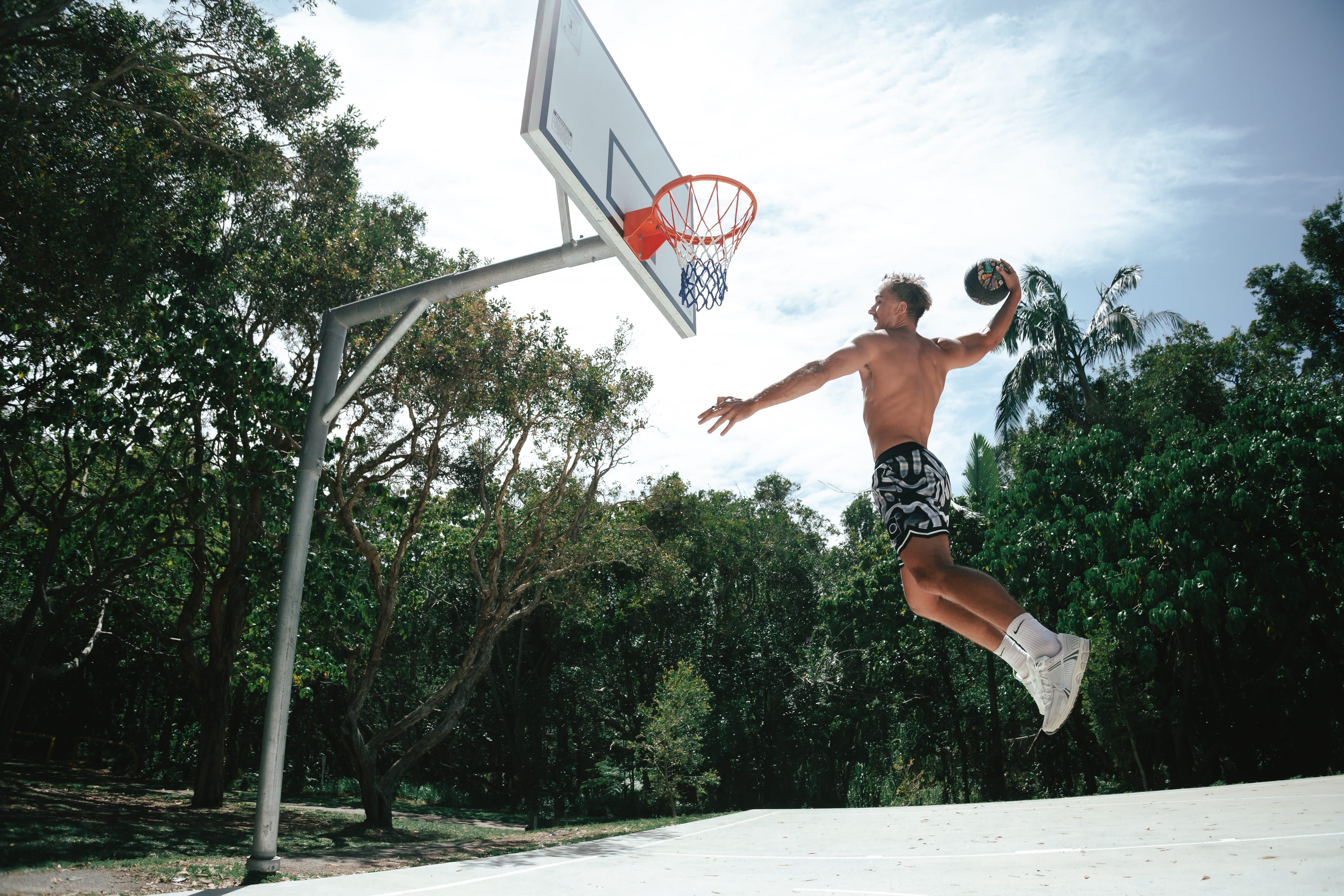 Courtside ROTY basketball shorts shown on Nelson NBL player shirtless flying through the air performing a dunk