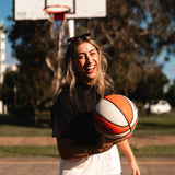 Courtside DPOY basketball shorts in cream with orange & black highlights, shown on NBL1 player Nicola Watkins