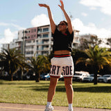 Courtside DPOY basketball shorts in cream with orange & black highlights, shown on NBL1 player Nicola Watkins shooting a basket
