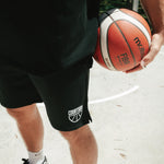Black basketball netted shorts, narrow, long legged, traditional short with white half ball courtside logo on bottom left leg front.