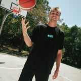 Black basketball netted shorts, narrow fit, long legged, traditional short with white courtside logo on bottom left leg front shown on smiling basketball player Nelson Kahler
