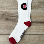 Pair of white socks with pink ball in a black C hoop logo, pink toes and heels shown flat