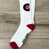 Pair of white socks with pink ball in a black C hoop logo, pink toes and heels shown flat