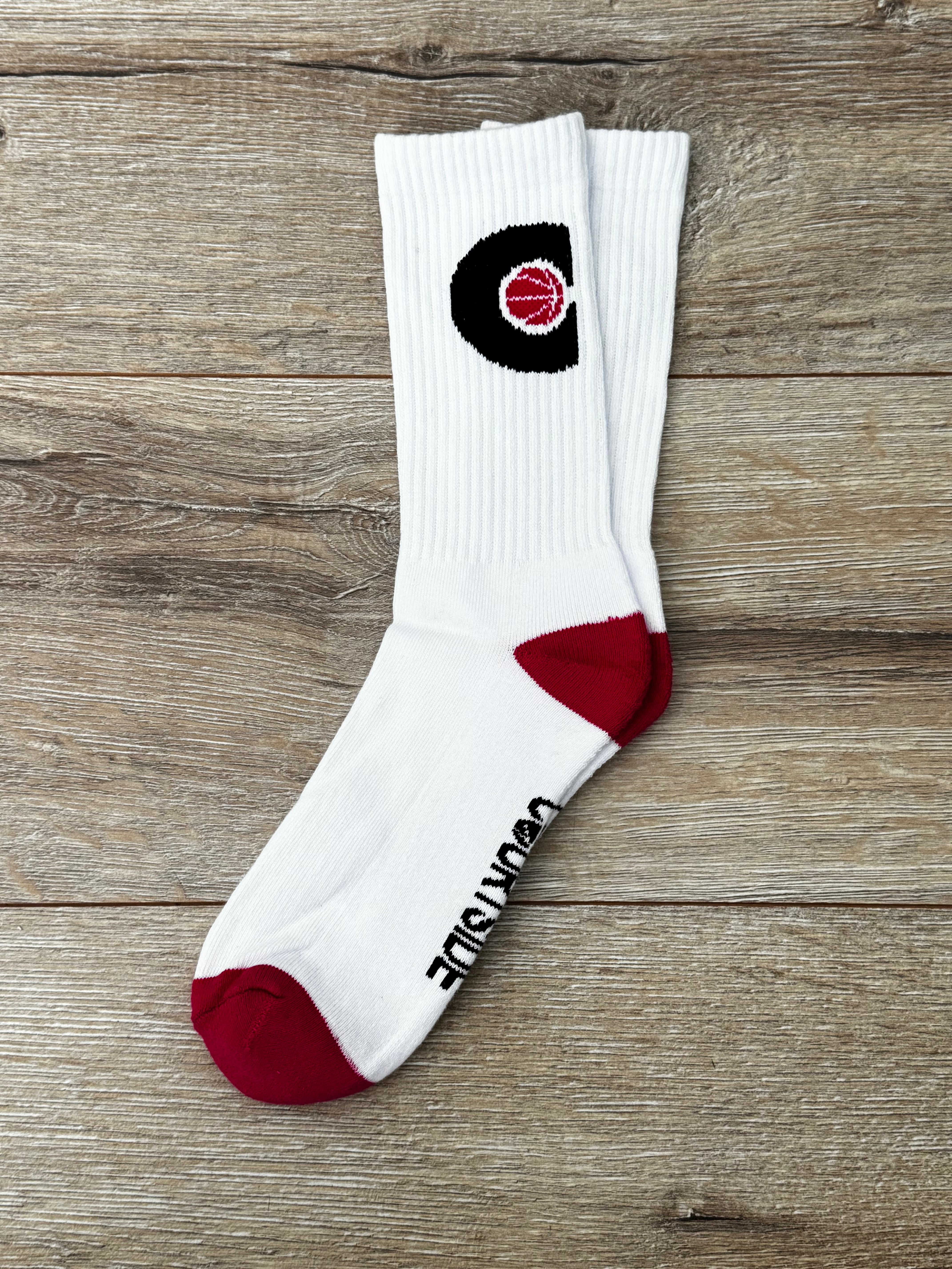 Pair of white socks with pink ball in a black C hoop logo, pink toes and heels shown flat