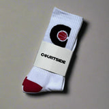 Pair of white socks with pink ball in a black C hoop logo, pink toes and heels shown in packaging