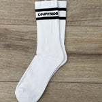 pair of white socks with courtside written along top with black stripe top & bottom
