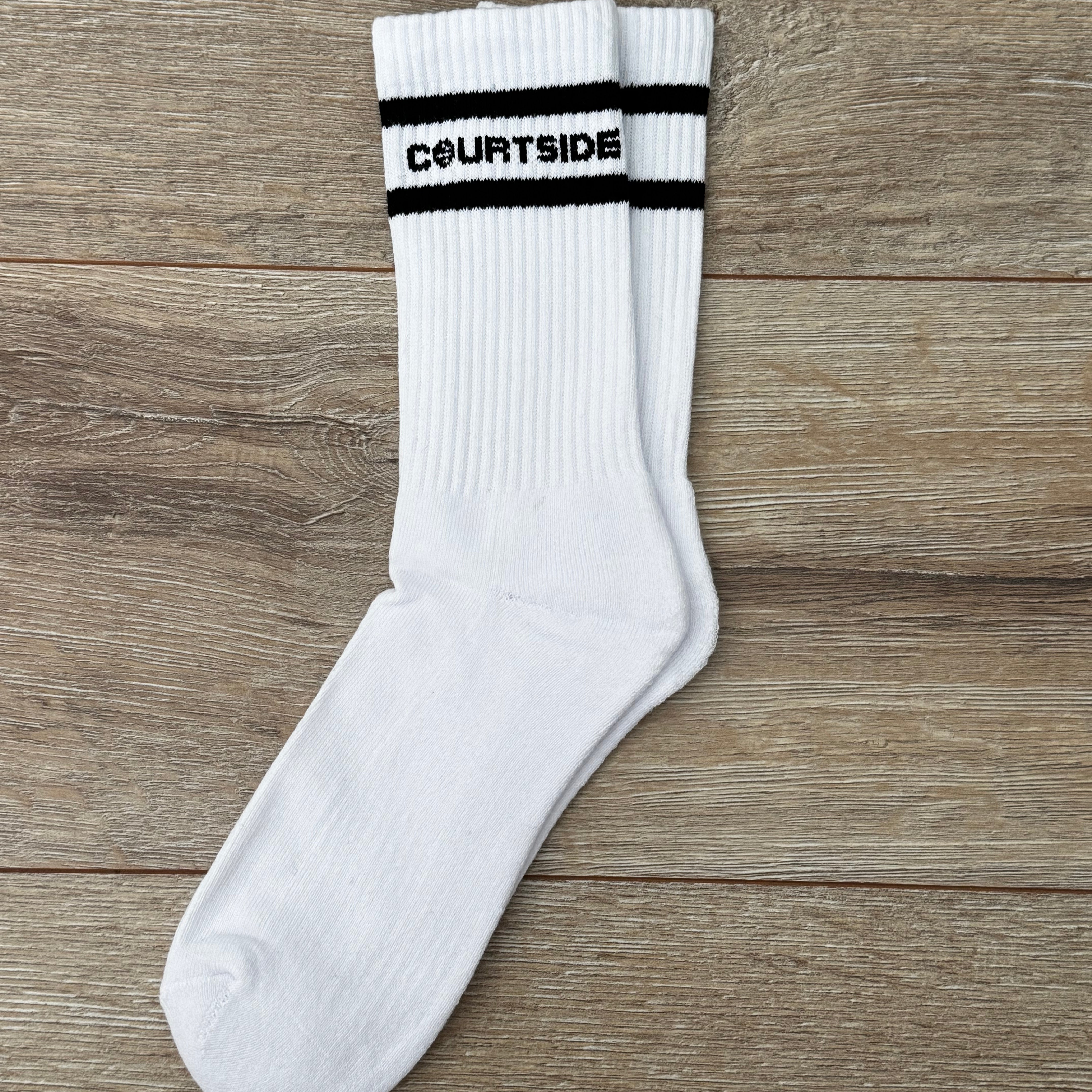 pair of white socks with courtside written along top with black stripe top & bottom