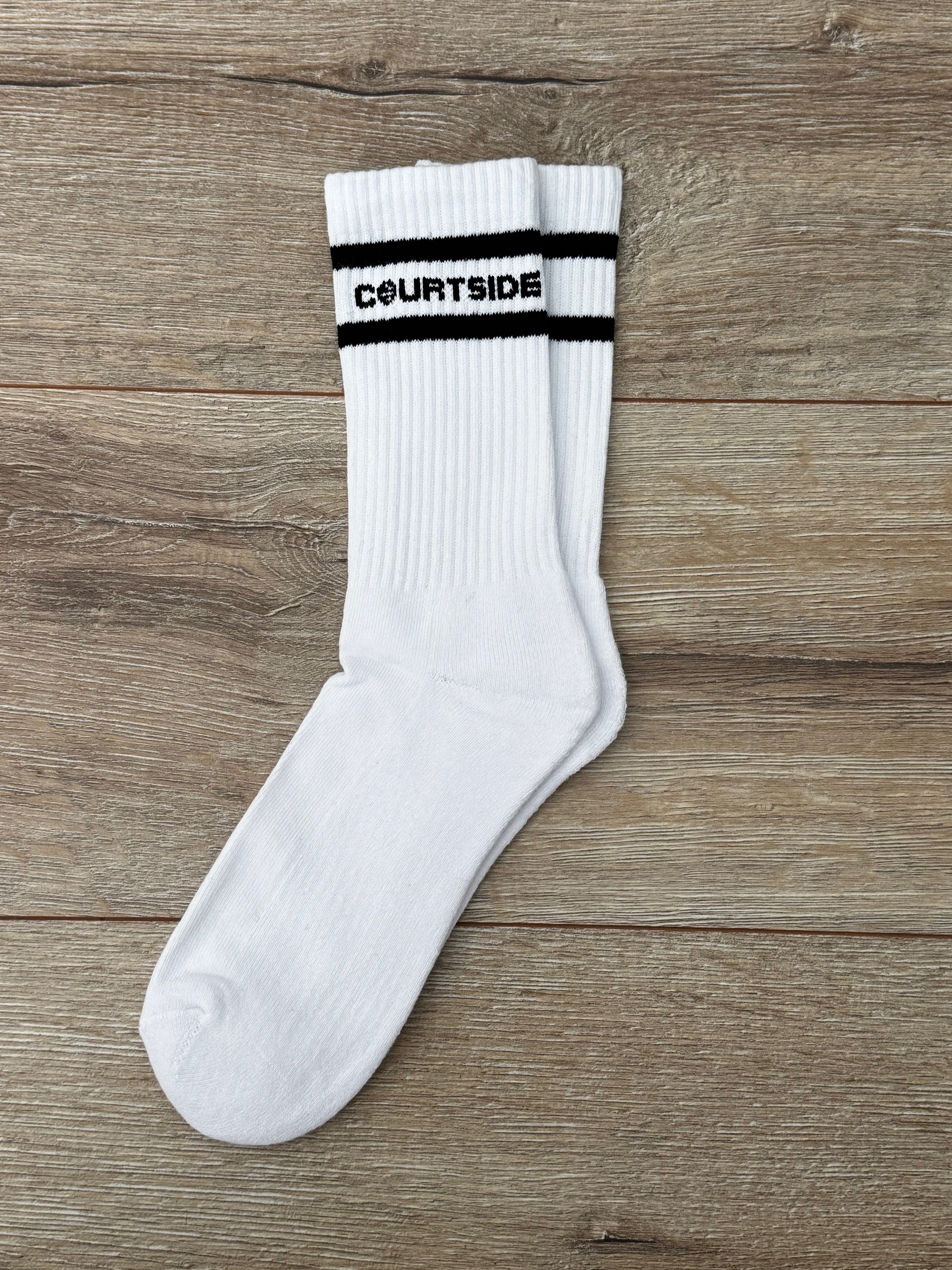 pair of white socks with courtside written along top with black stripe top & bottom