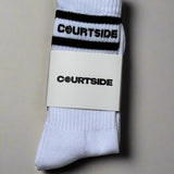 pair of white socks with courtside written along top with black stripe top & bottom shown in packaging