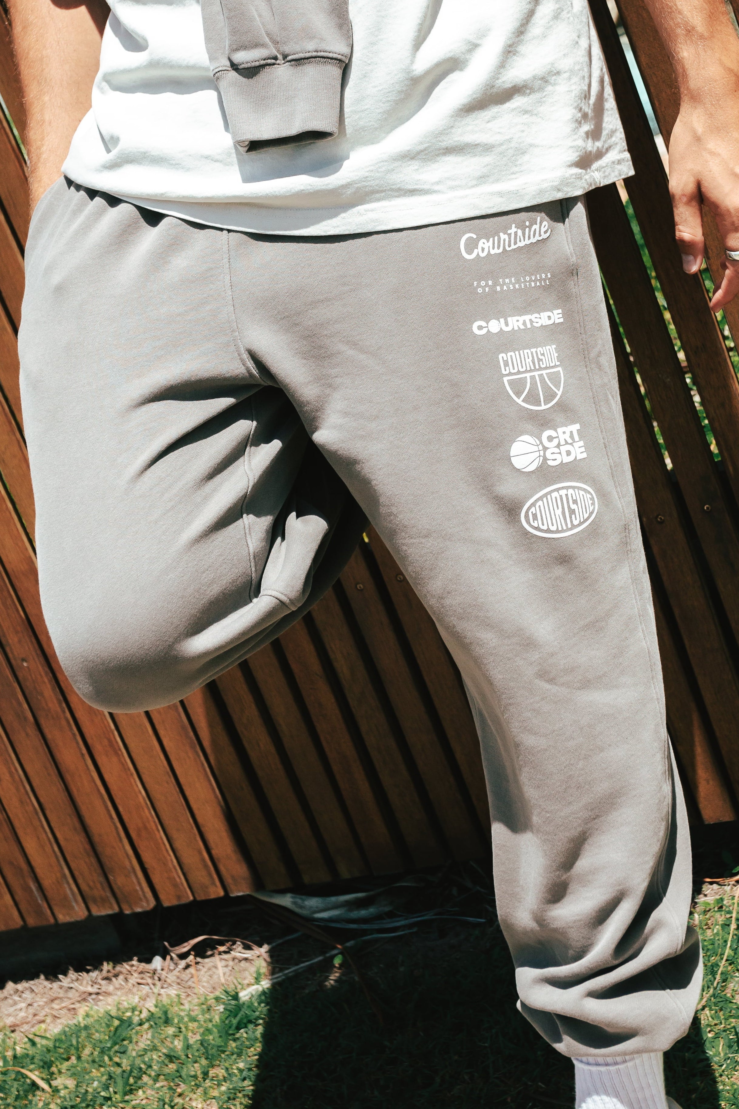 NBL Player Nelson Kahler wearing the Courtside Bench Track Pants in Faded Grey colour.