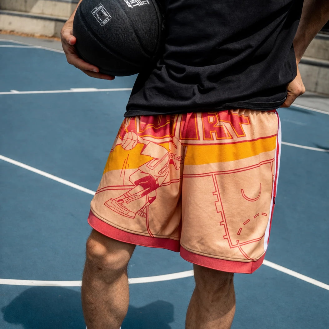 Person holding a basketball on a court wearing a black shirt and colorful shorts.
