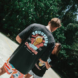 NBL Player Nelson Kahler and Gabi wearing the Courtside Champs Tee in Faded Black colour.