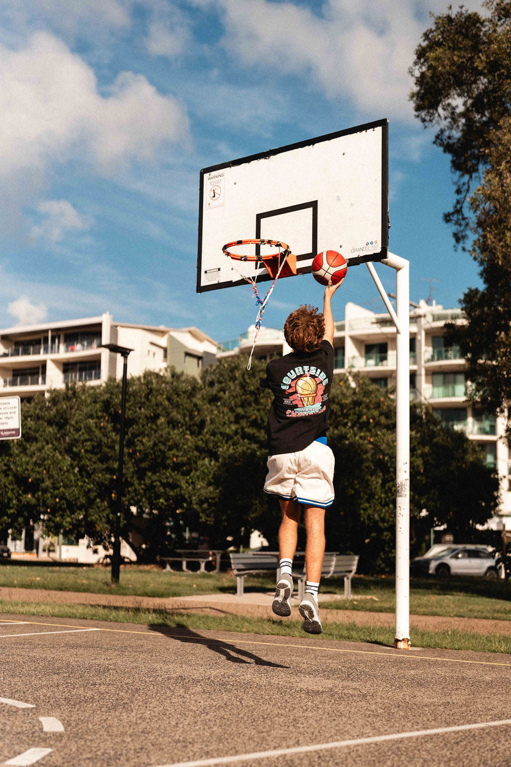 basketball player wearing champs tee shown hooping