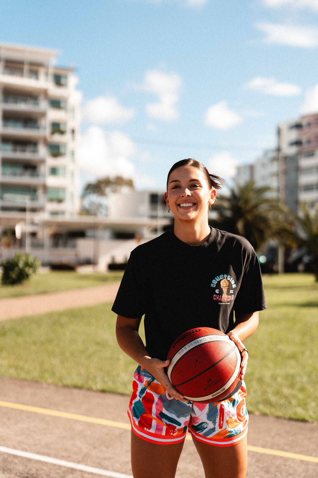 champs tee shirt showing front with female basketball player holding basketball