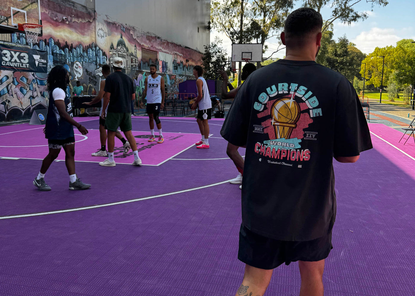 Egal commentator in Melbourne 3x3 outdoor basketball event, showing the relaxed community culture whilst wearing our best selling Courtside champs tee.