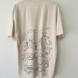 Bone t-shirt with black handdrawn graphic design on back, placed on a wooden hanger against a white wall