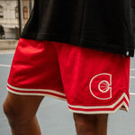 Red basketball shorts with a logo on a court
