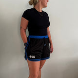 Female basketball player wearing the Courtside Black & Royal Blue DPOYW basketball short in women's cut showing details
