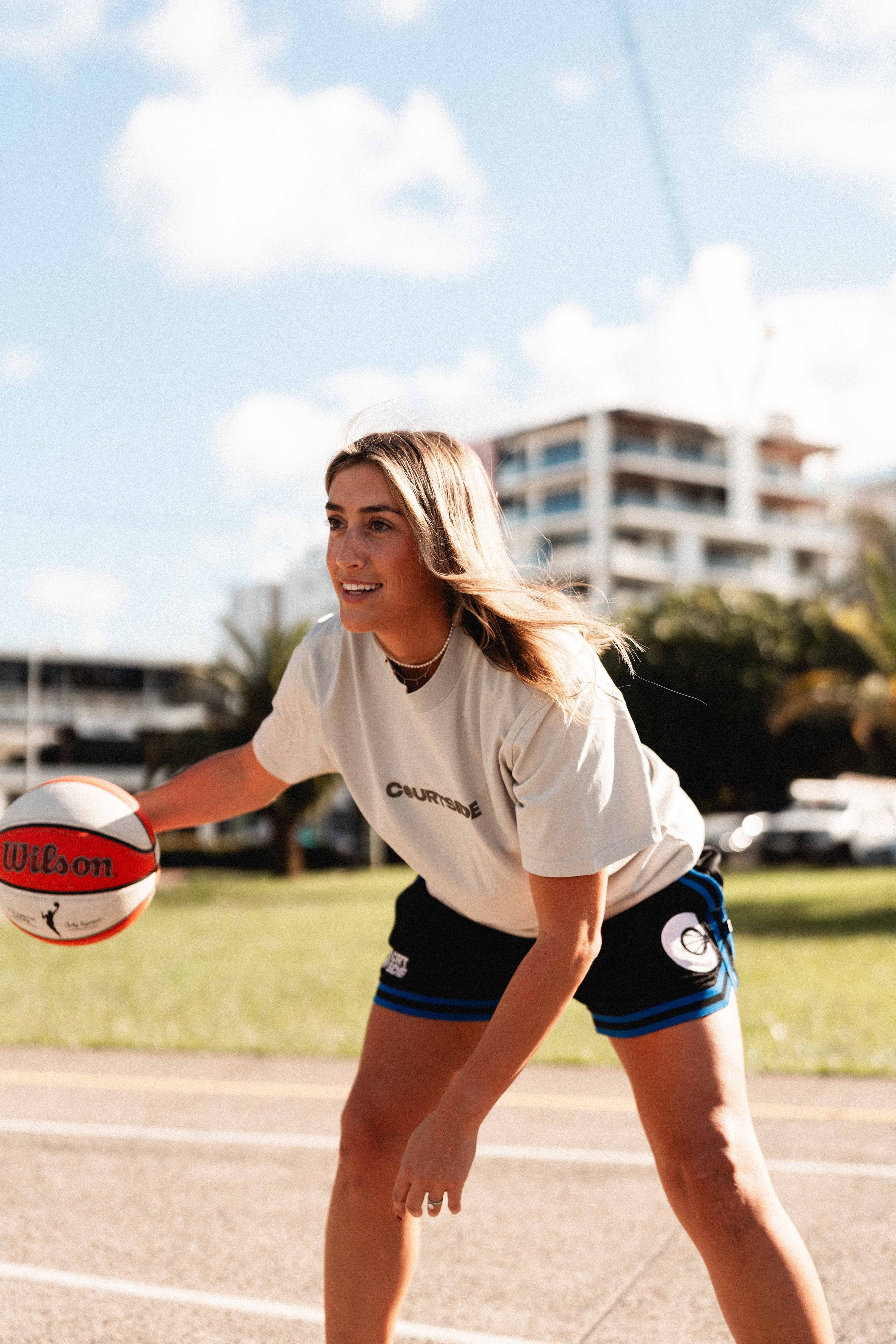 Female basketball player wearing the Courtside Black & Royal Blue DPOYW basketball short in women's cut showing details