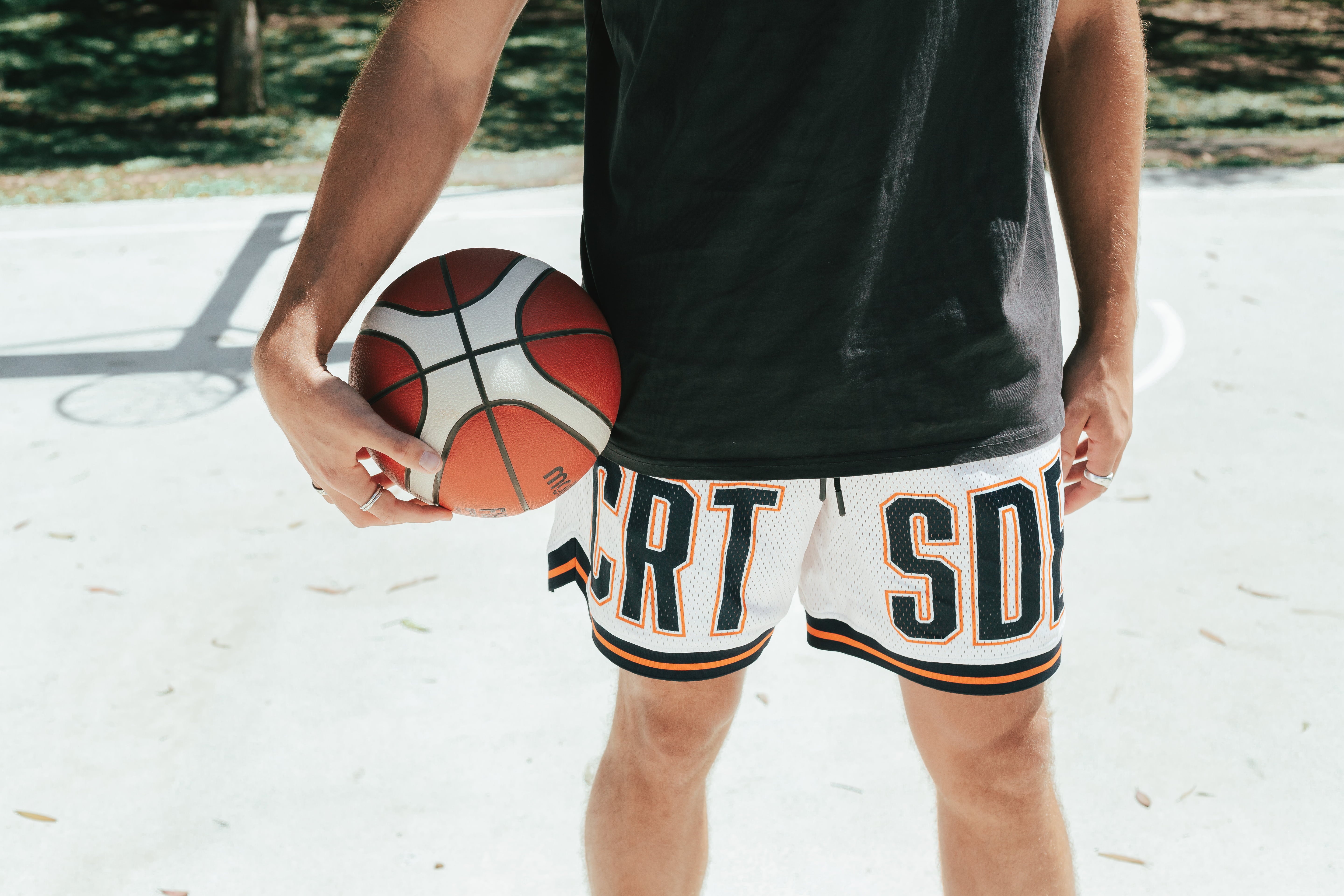 Courtside DPOY basketball shorts with CRT SDE letters in bold across front leg shown on Nelson Kahler NBL player close up of legs