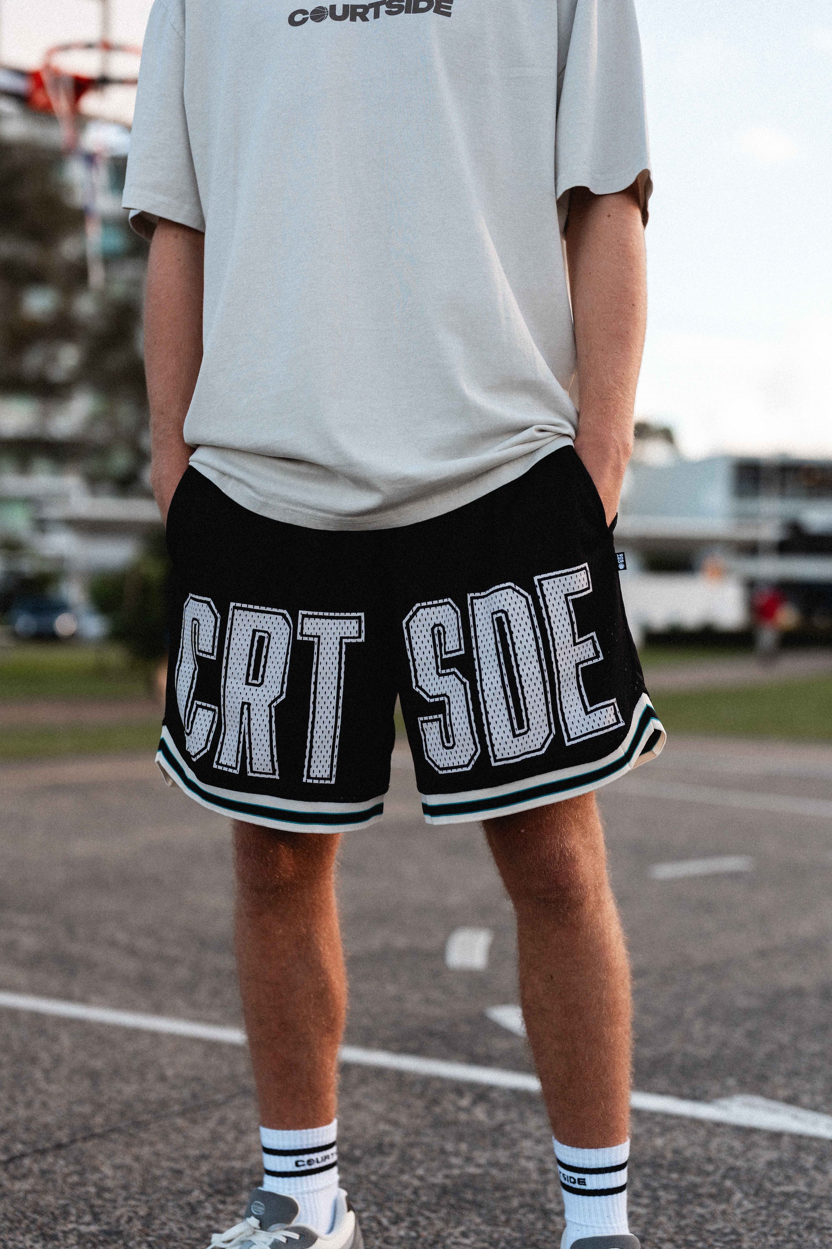 Courtside Black basketball shorts on Louis Lauret elite junior basketball player with white large letters across front CRT SDE short for Courtside with Teal detailing.