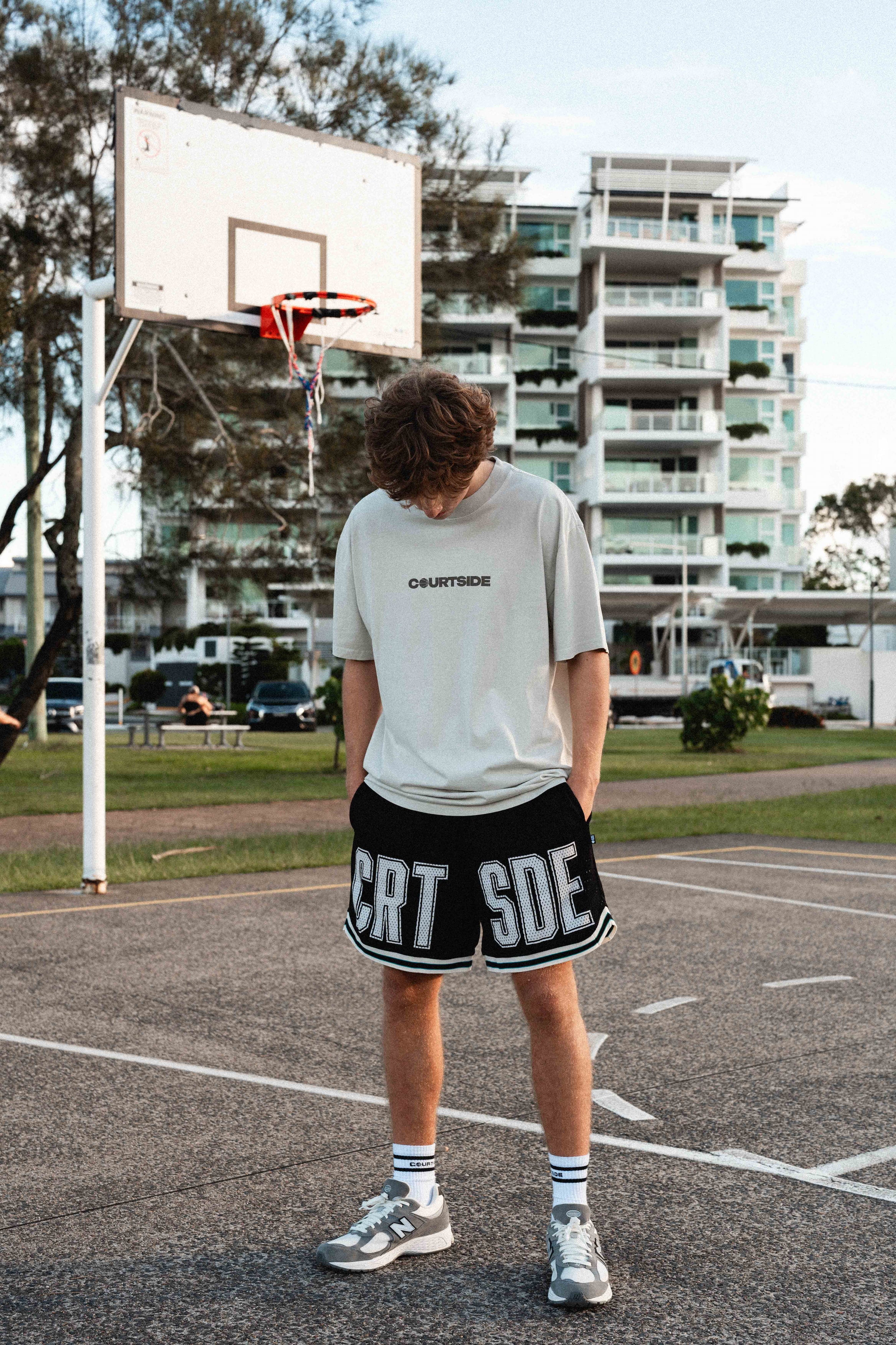 Courtside Black basketball shorts on Louis Lauret elite junior basketball player with white large letters across front CRT SDE short for Courtside with Teal detailing.