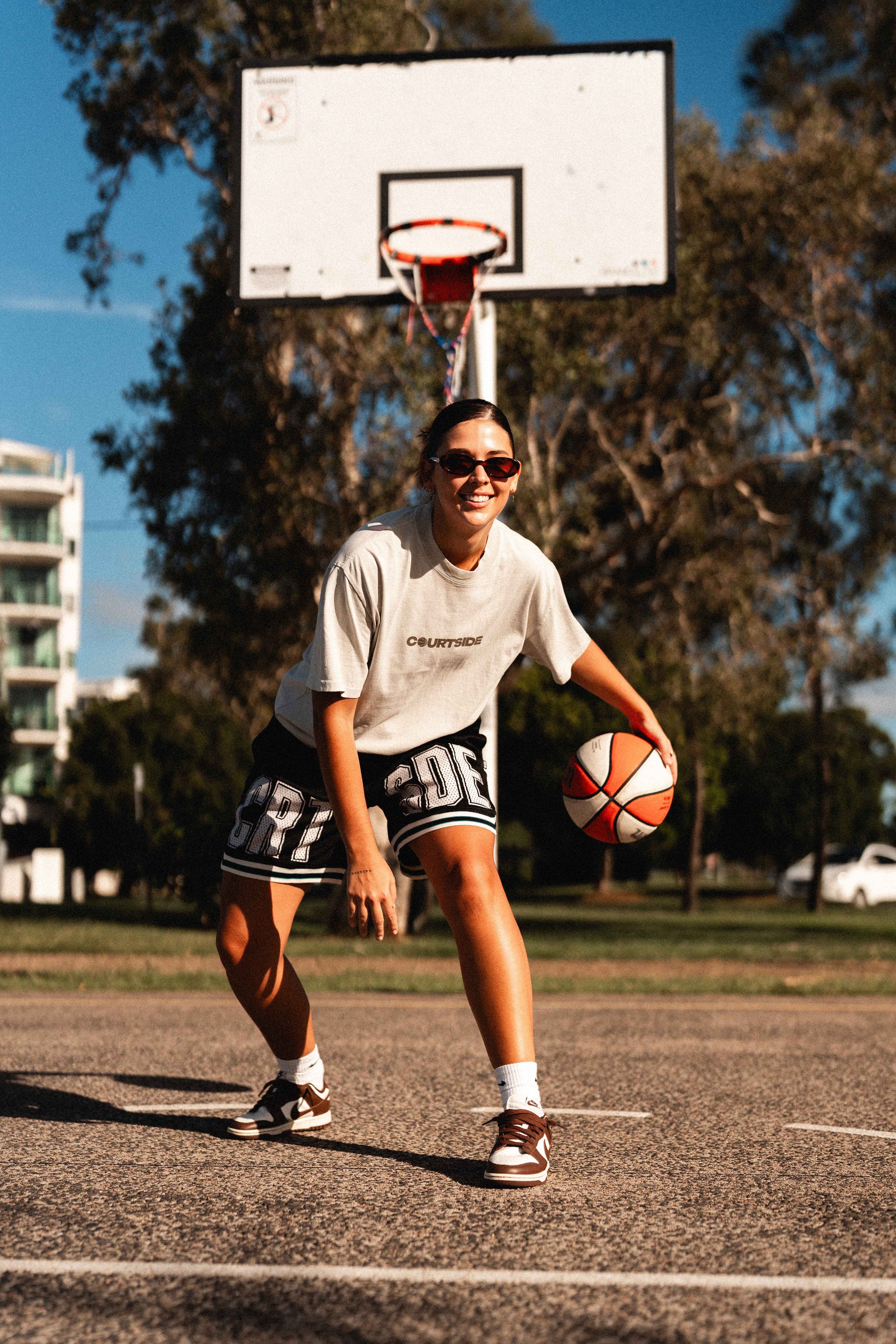 Courtside Black basketball shorts on NBL1  basketball player Ash Frampton with white large letters across front CRT SDE short for Courtside with Teal detailing.