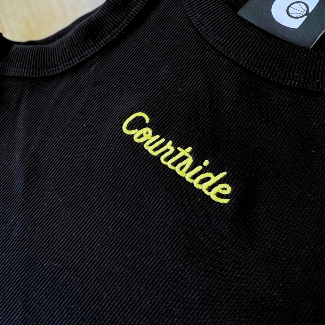 Black crop tank top with Courtside embroidered in yellow
