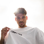 Man holding a white t-shirt with 'COURTSIDE' text against a bright background
