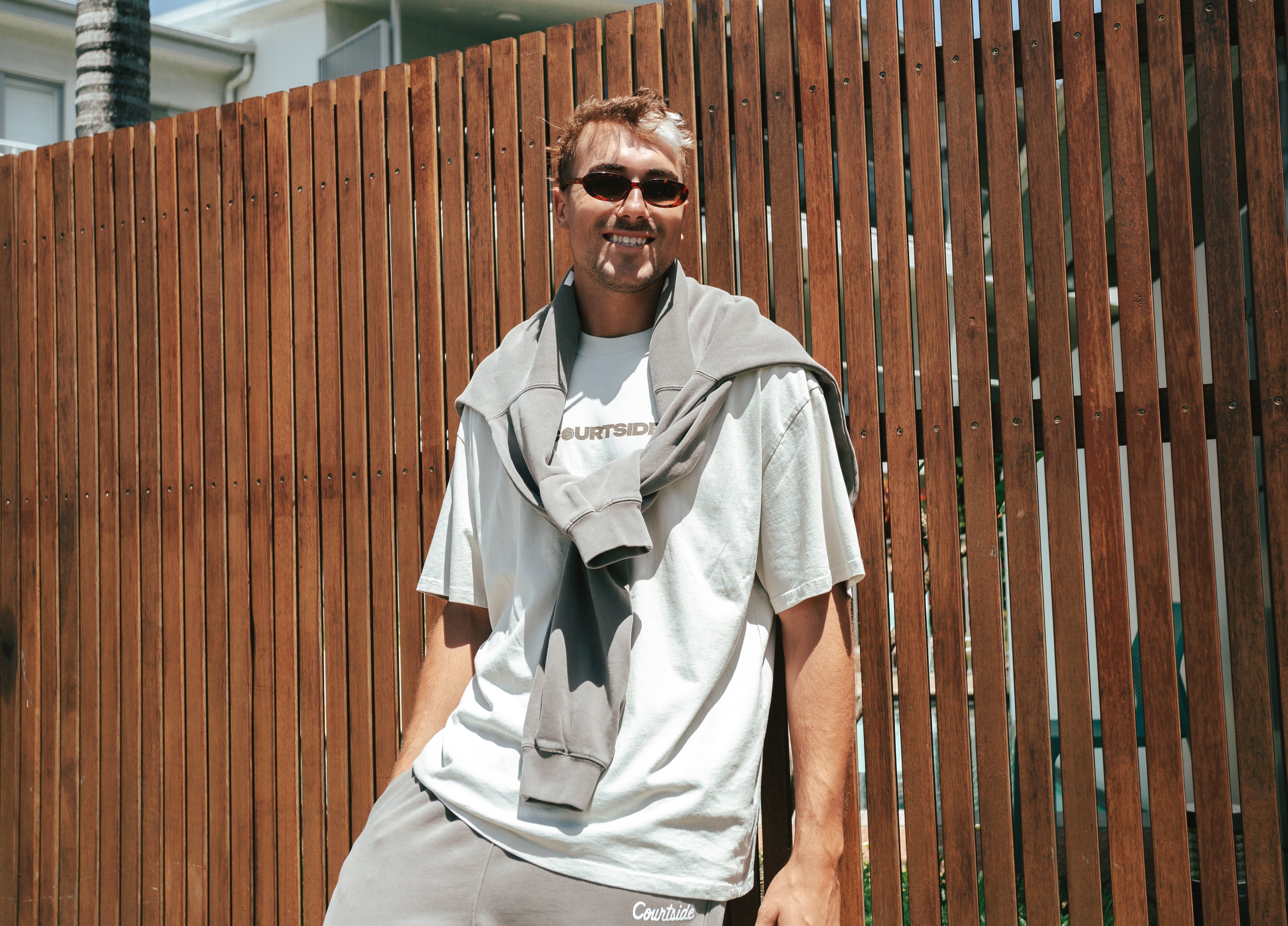 Male basketball player wearing Courtside Koby Tee in faded bone - front view showing relaxed fit