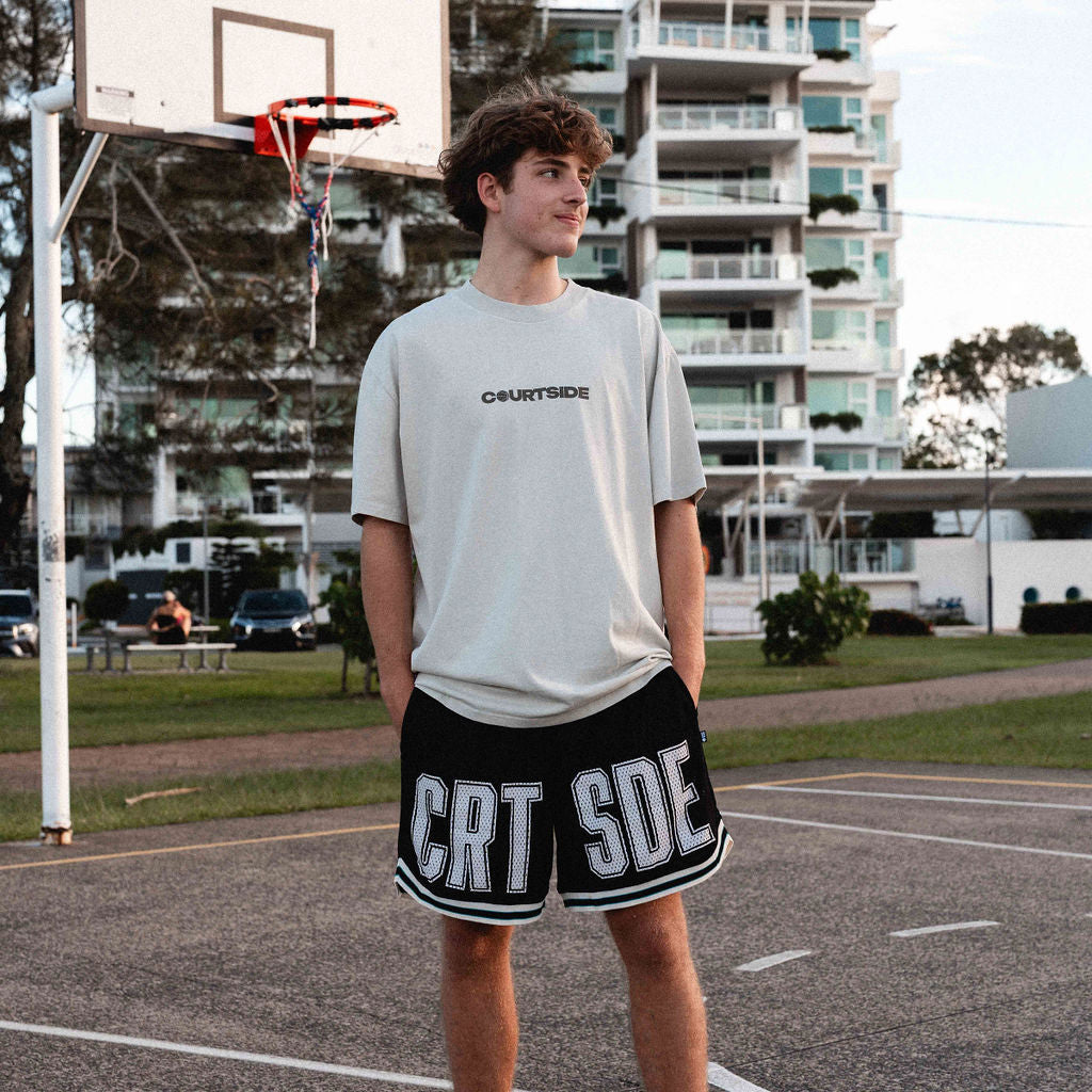young male basketball player wearing the Koby tee in faded bone and courtside basketball shorts and socks.