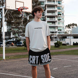 young male basketball player wearing the Koby tee in faded bone and courtside basketball shorts and socks.