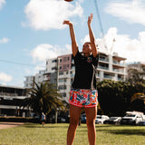 NBL1 player Ash Frampton shooting hoops wearing MVPW orange and colourful basketball shorts and black champs tee at Cotton Tree outdoor court in Sunshine Coast