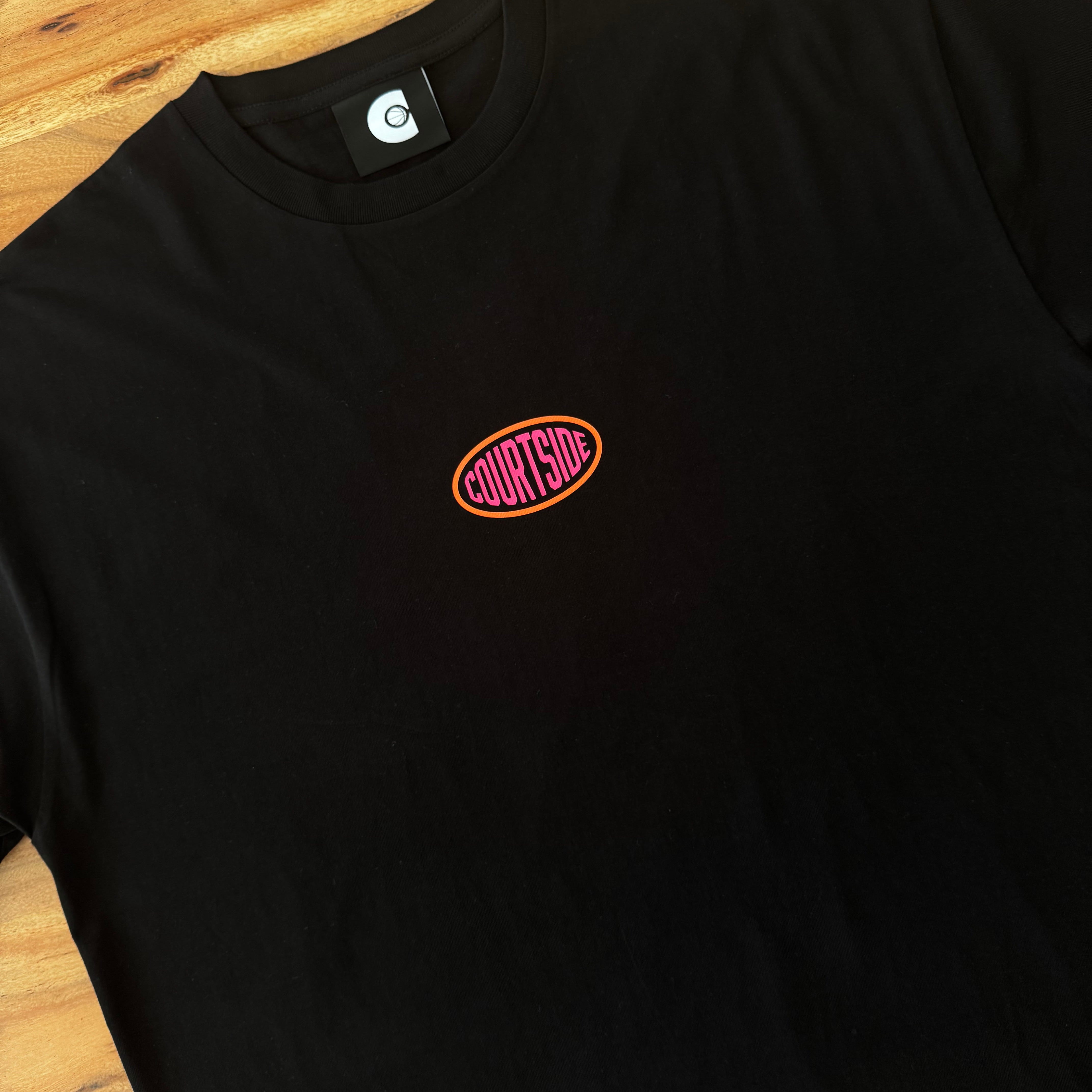 Black t-shirt with a small Courtside logo on a wooden surface